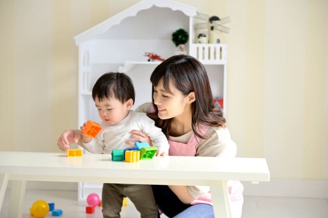 保育者と一緒に、積み木あそびを楽しむ子ども